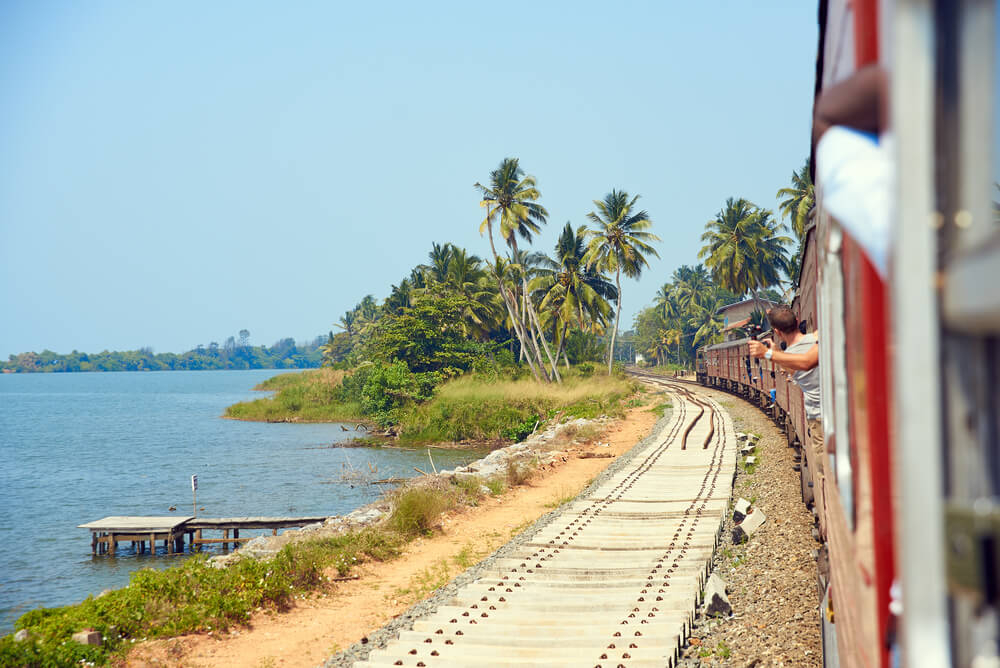 Sri Lanka mit dem Zug: Fahrt entlang der Küste mit Blick auf schönen Strand.