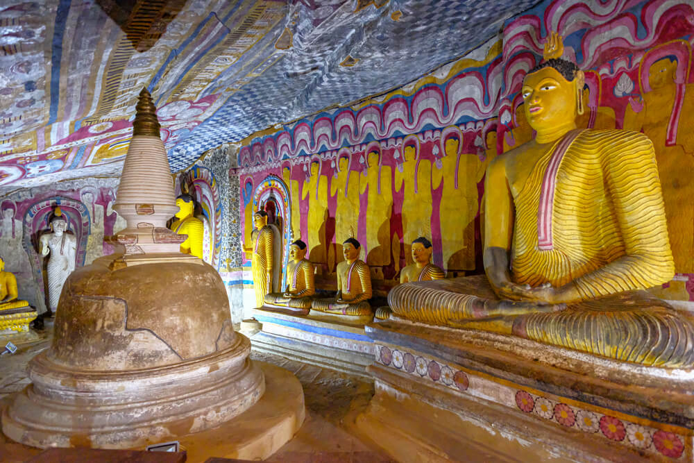 Sri Lanka Attraktionen: Buddha-Statuen und Wandmalereien im Inneren einer Höhle.