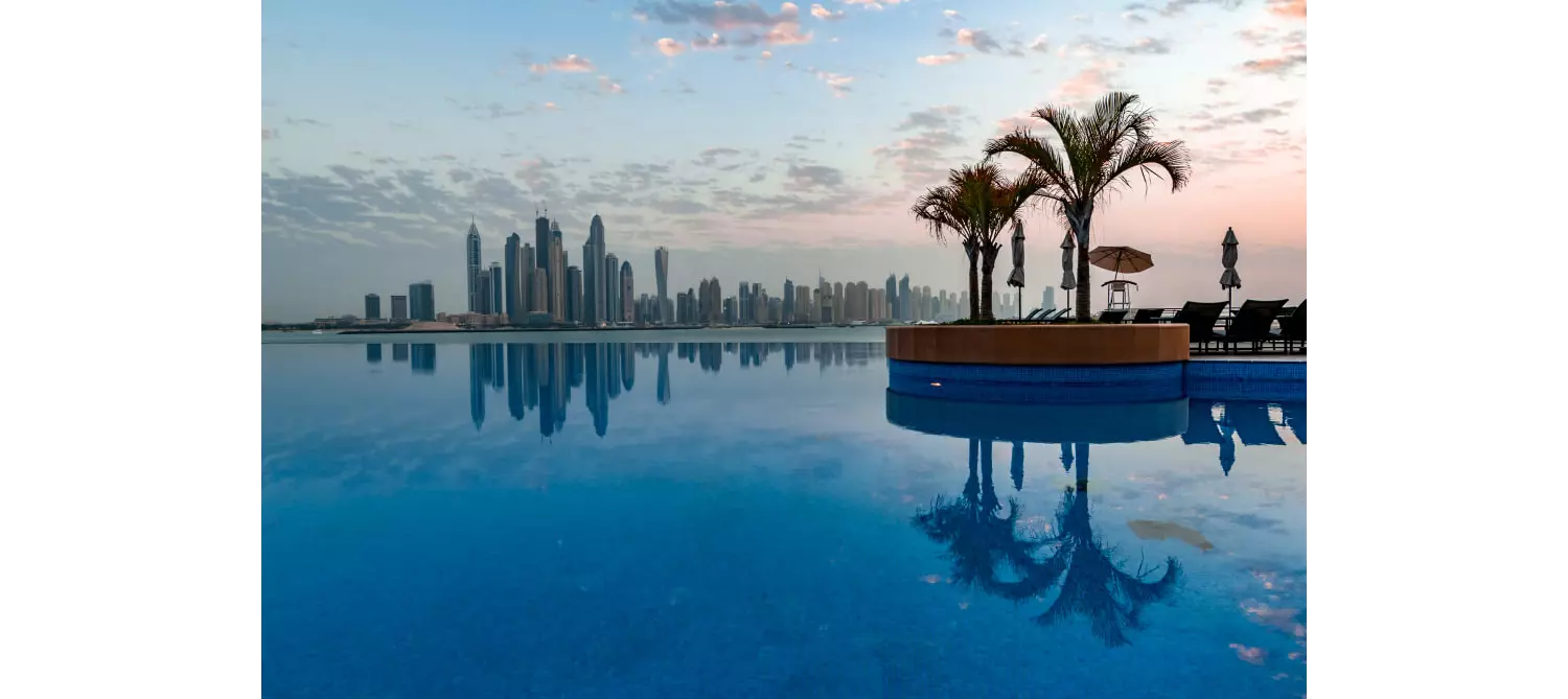 Dukes The Palm: An infinity pool with a small bar in the middle and views of Dubai