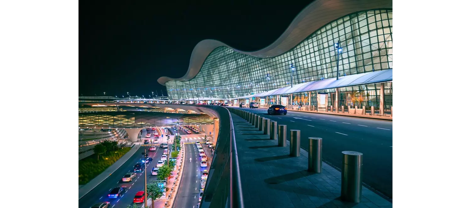 Stopover in Dubai: The airport in Dubai lit up at night, seen from the side