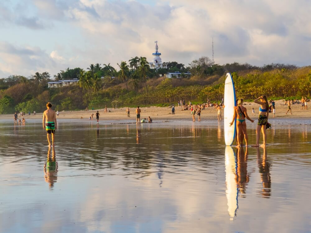 Surfen in Costa Rica: Menschen mit Surfbrett am Playa de Tamarindo.