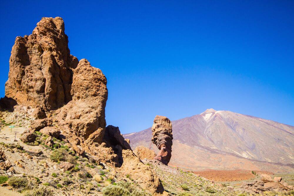 Roques de García: A barren, red, rocky, volcanic landscape with an outcrop and volcano