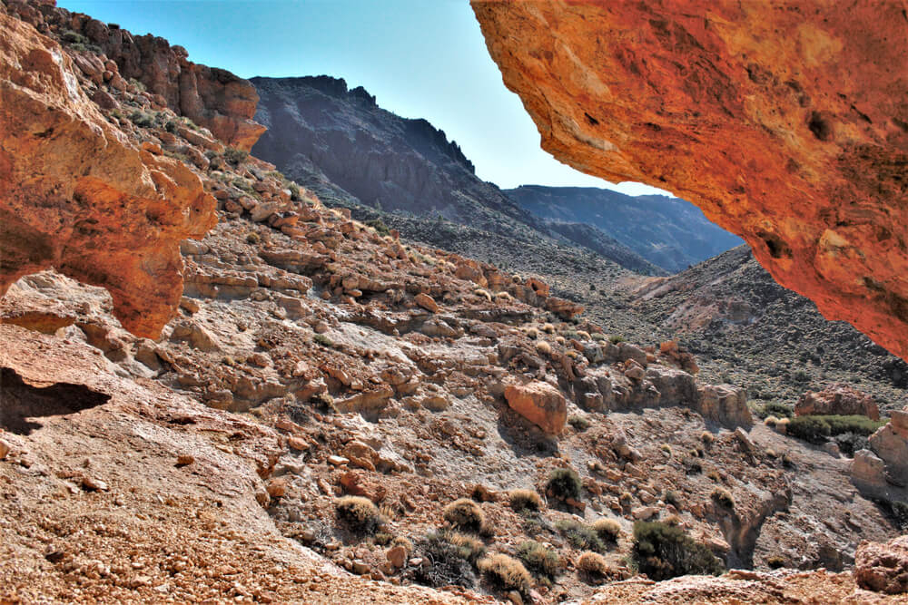 Teide by Car: A rocky expanse framed by a reddish rocky cliff