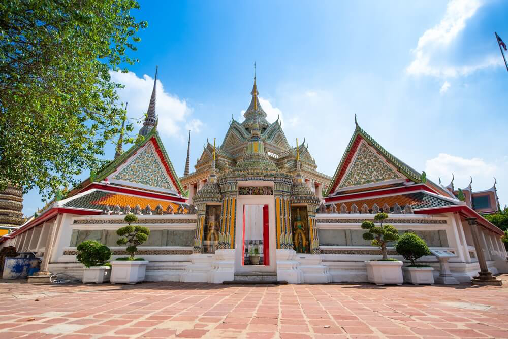Wat Pho: A white temple with ornate green, red and yellow details