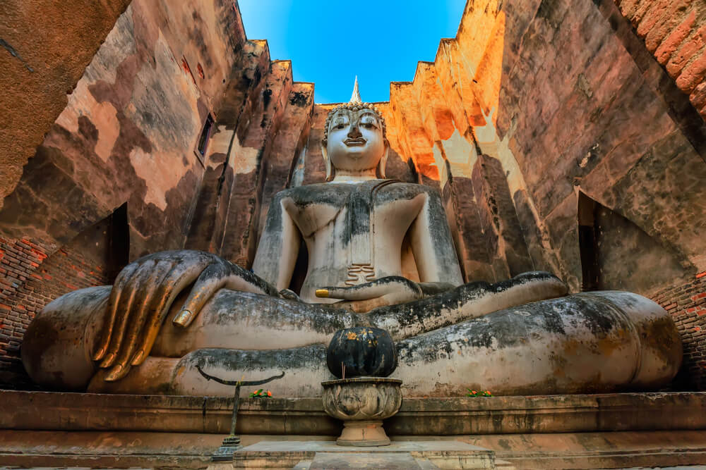 Wat Si Chum: A massive stone Buddha statue set inside a brick wall facade