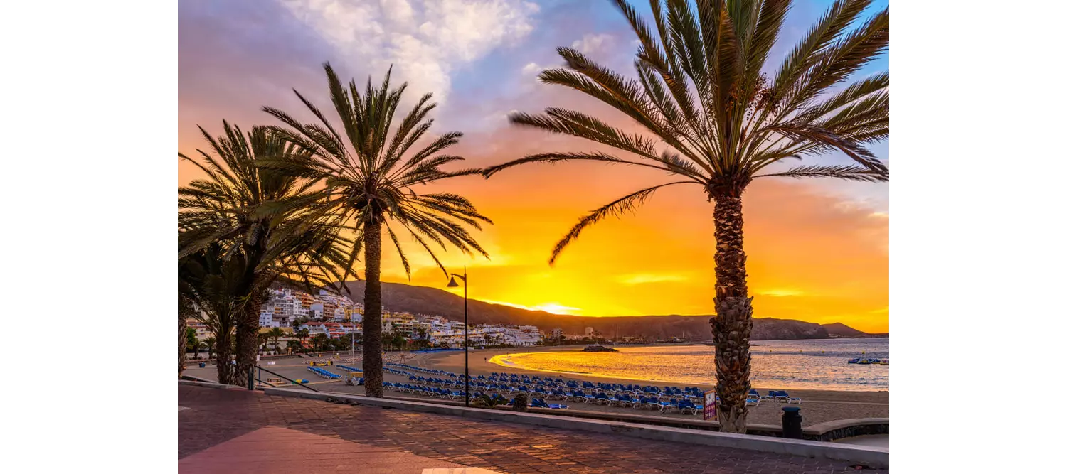 Teneriffa schönste Strände: Strandpromenade mit Palmen in der Dämmerung.