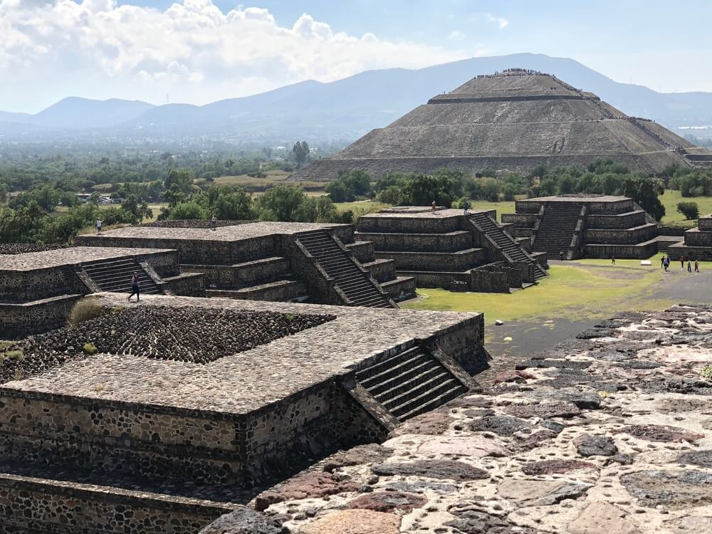 Kleinere Gebäude vor der großen Sonnenpyramide in Mexiko.