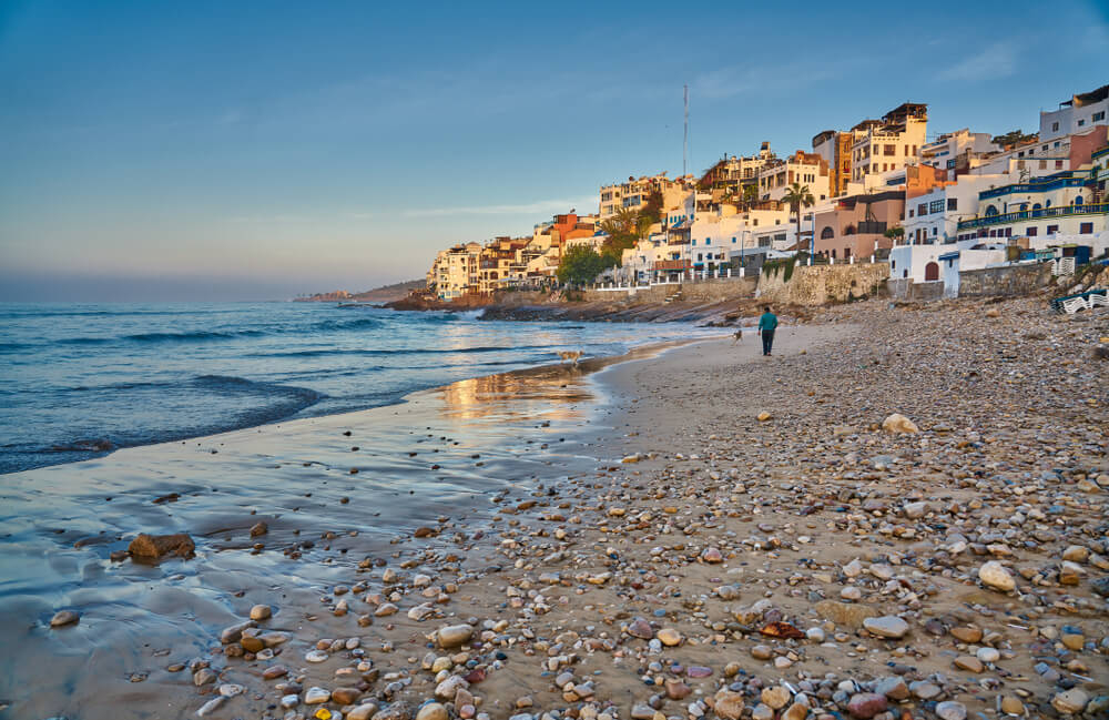 Taghazout Beach: Rocky sandy coastline with a town in the hills