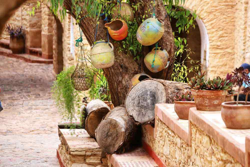 Things to do in Agadir: A traditional street with clay pots hanging from a tree