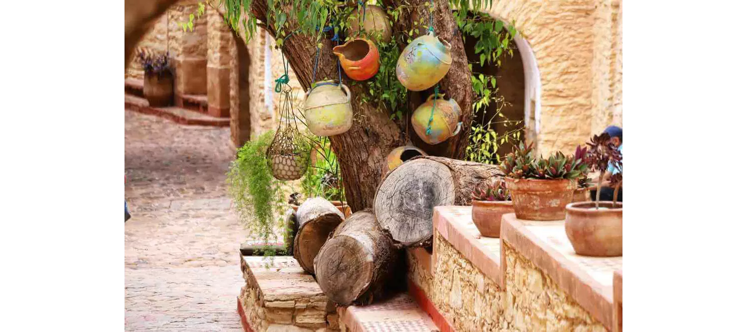 Things to do in Agadir: A traditional street with clay pots hanging from a tree