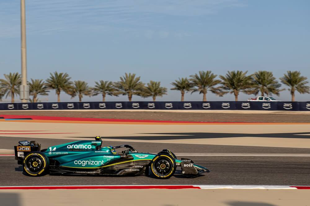 Formula 1: A green formula 1 car racing on the Sakhir track in Bahrain