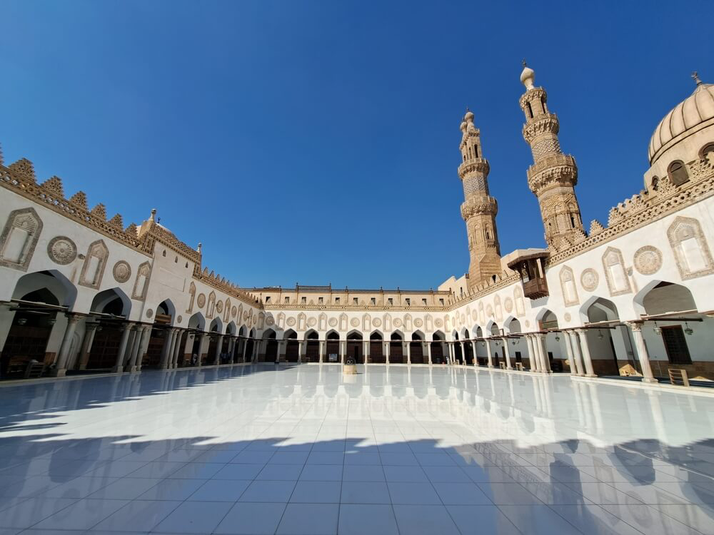 Al-Azhar Mosque: White internal patio with white gallery walls surrounding it and two turrets 