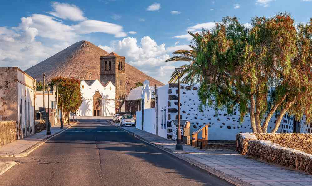 Things to do in Fuerteventura: An old whitewashed town with palm trees and a volcano