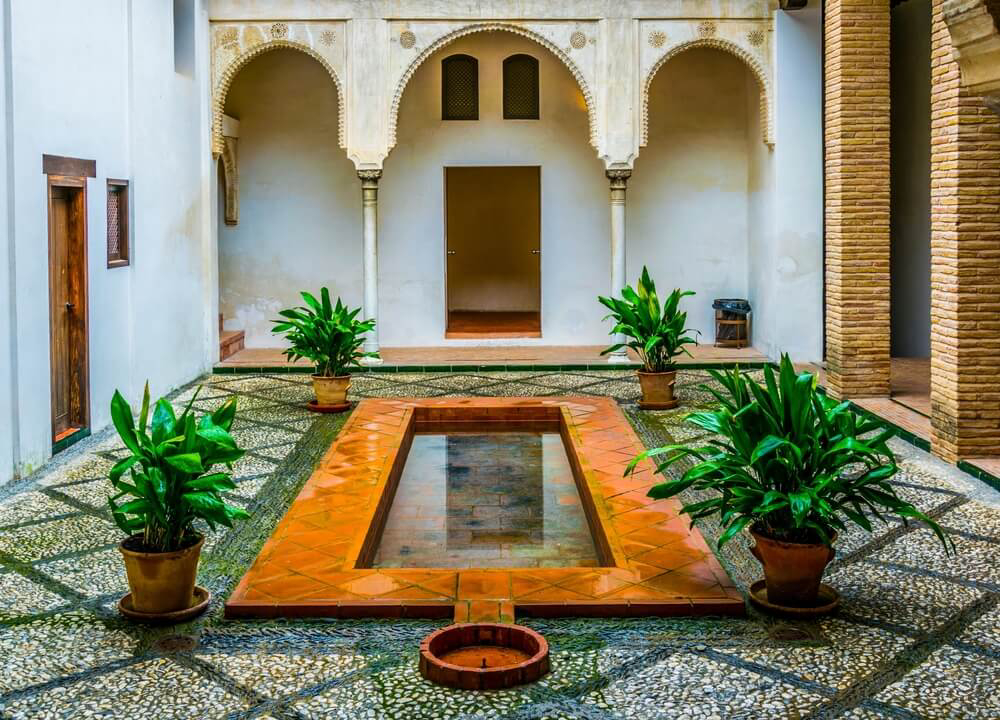 Casa Horno de Oro: A cobbled patio in an arched courtyard with a central pool