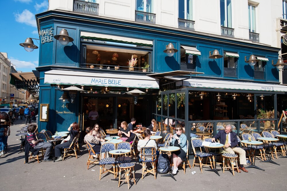 Cafés: A street in Le Marais lined with a blue coffee shop and terrace