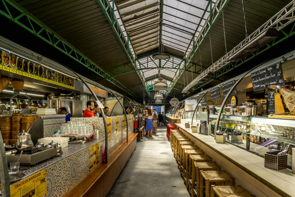 Enfants Rouges: A white tiled market stall with people shopping and eating