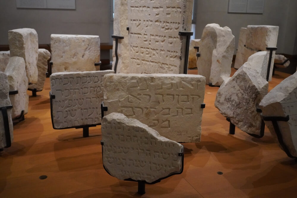 Jewish Art: A museum display with white carved tiles in Hebrew