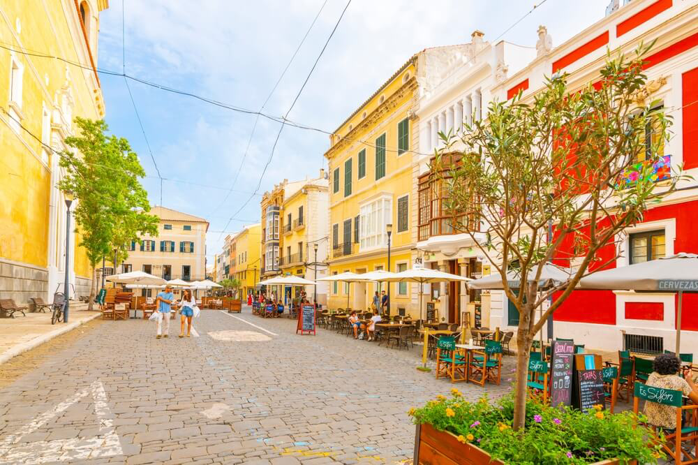 Things to do in Menorca: A cobbled street in Mahón, Menorca with coloured buildings