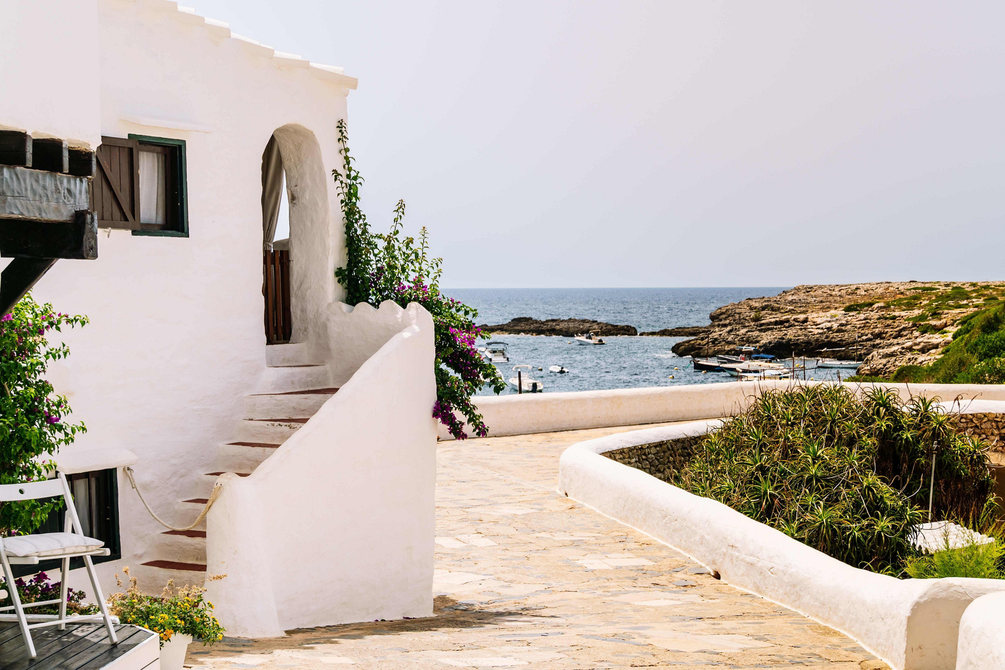 Things to do in Menorca: A white traditional home overlooking the sea