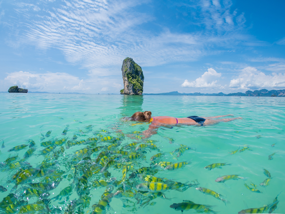 Best places to go in Phuket: Turquoise ocean filled with fish and woman snorkelling