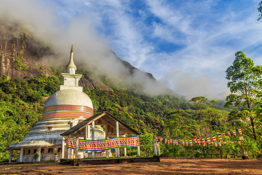 Adam’s Peak: A close-up of the white Buddhist temple decorated with bunting on top of the mountain