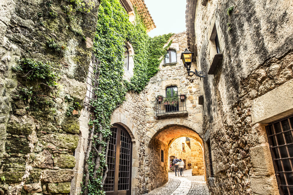 Pals: The tall stone city walls and archway in the centre of Pals, Girona
