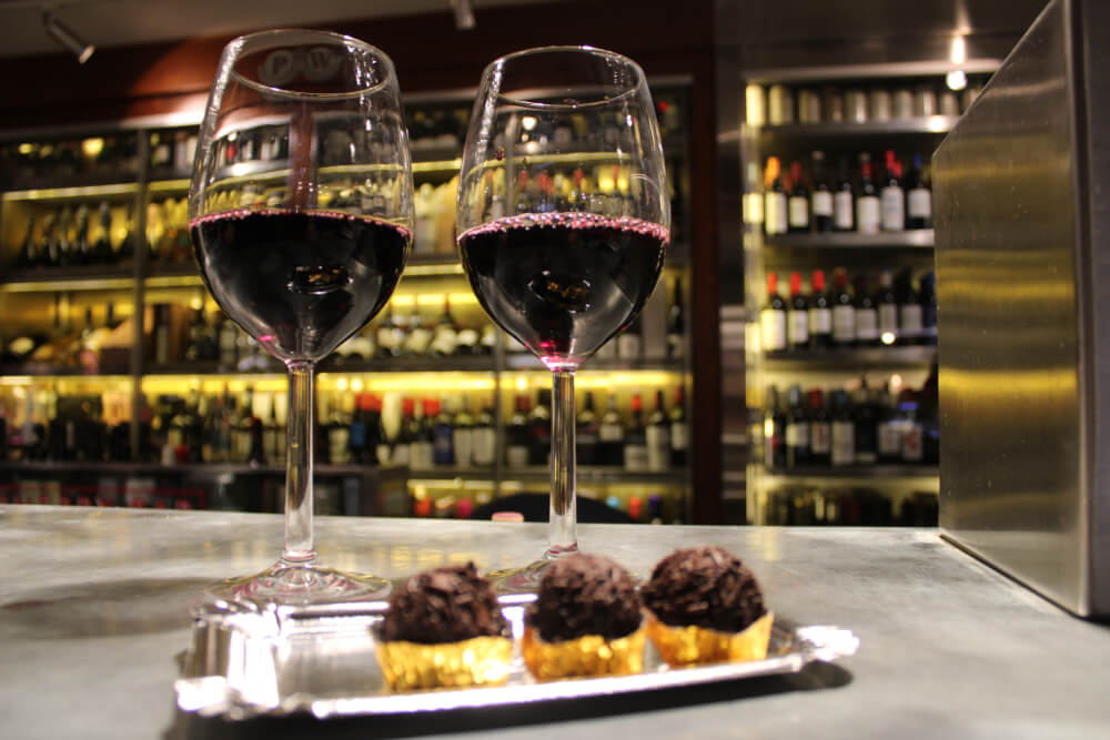 Spanish wine: Two red wine glasses on the side of a bar with a plate of tapas