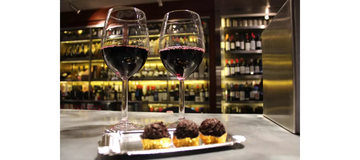 Spanish wine: Two red wine glasses on the side of a bar with a plate of tapas