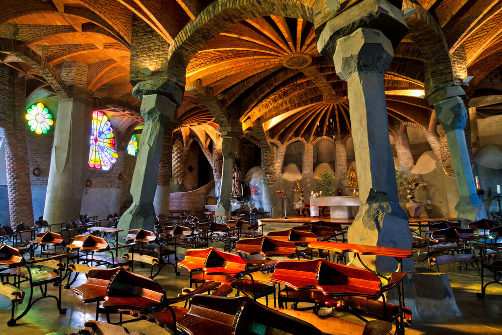 Light shines in on the modernist shapes of the Gaudí-designed church in Colonia Güell