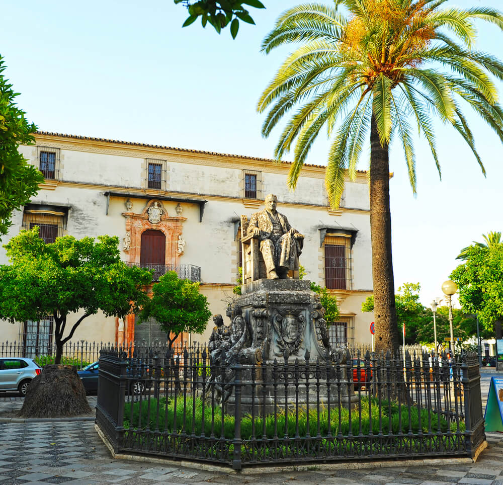 Palacio Domecq: A white colonial style mansion view from across a patio with a palm tree