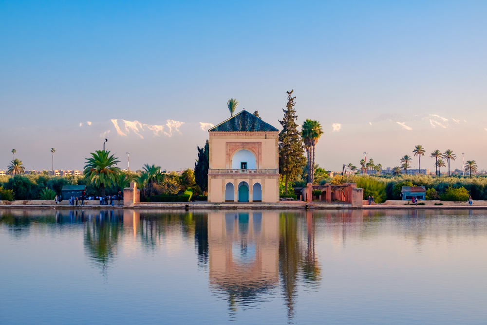 Manara Gardens: A large pond of water and a small pink building amongst trees