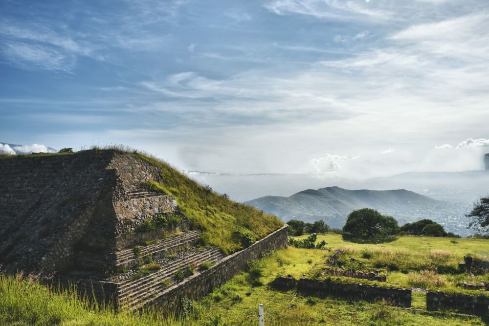 Monte Albán: A stone pyramid surrounded by greenery 
