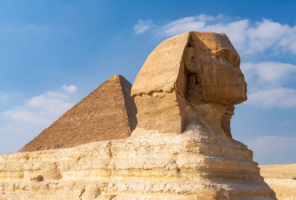 Egypt: A close up of a statue and pyramid at the Pyramids of Giza 