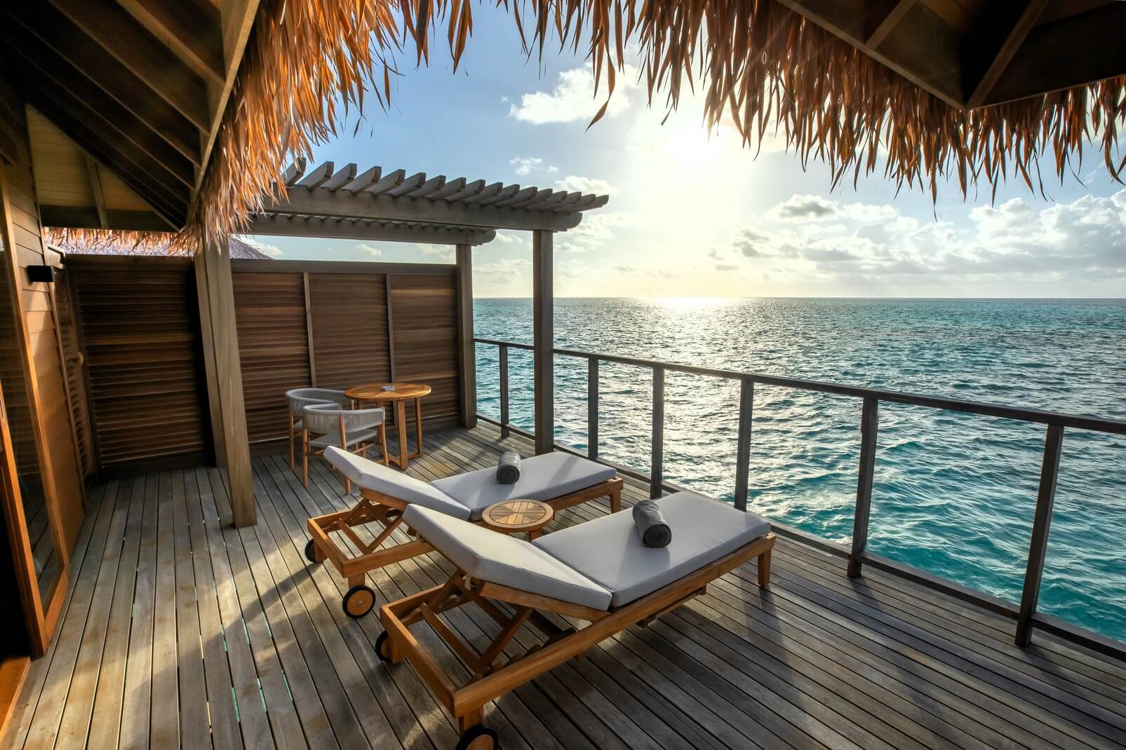 Maldives: Two loungers on the terrace of a villa overlooking the sea