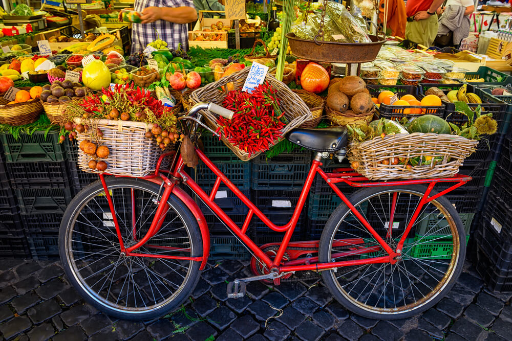 Marktstand mit einem Fahrrad und frischem Obst und Gemüse in Rom.