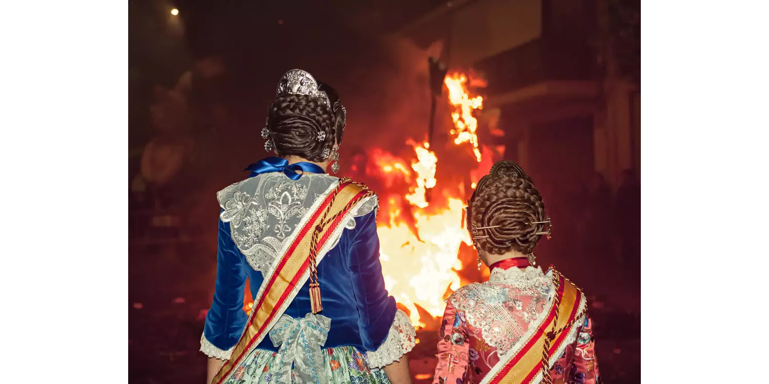 Unique experiences in Spain: two girls in traditional dress looking at a bonfire