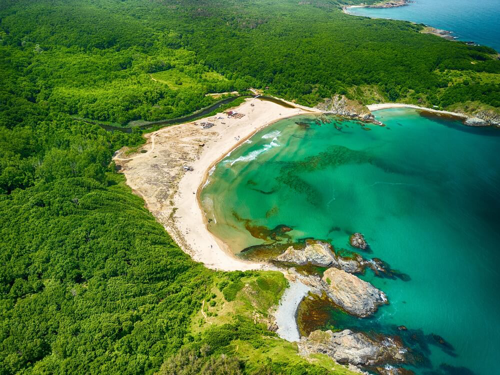 Luftaufnahme des Silistar Beach in Bulgarien, umgeben von dichtem Wald.