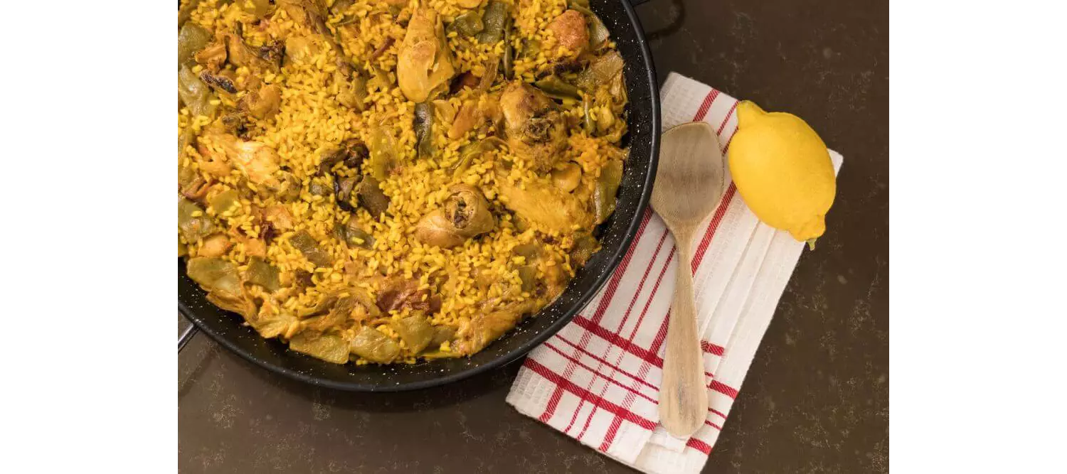 Die authentische valencianische Paella kommt mit wenigen Zutaten aus: Fleisch, Gemüse und Reis.