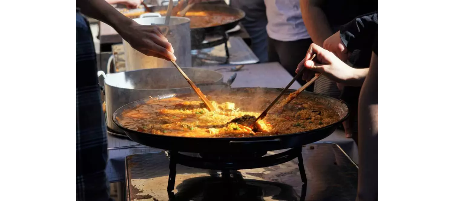 Köche bereiten eine authentische valencianische Paella zu.