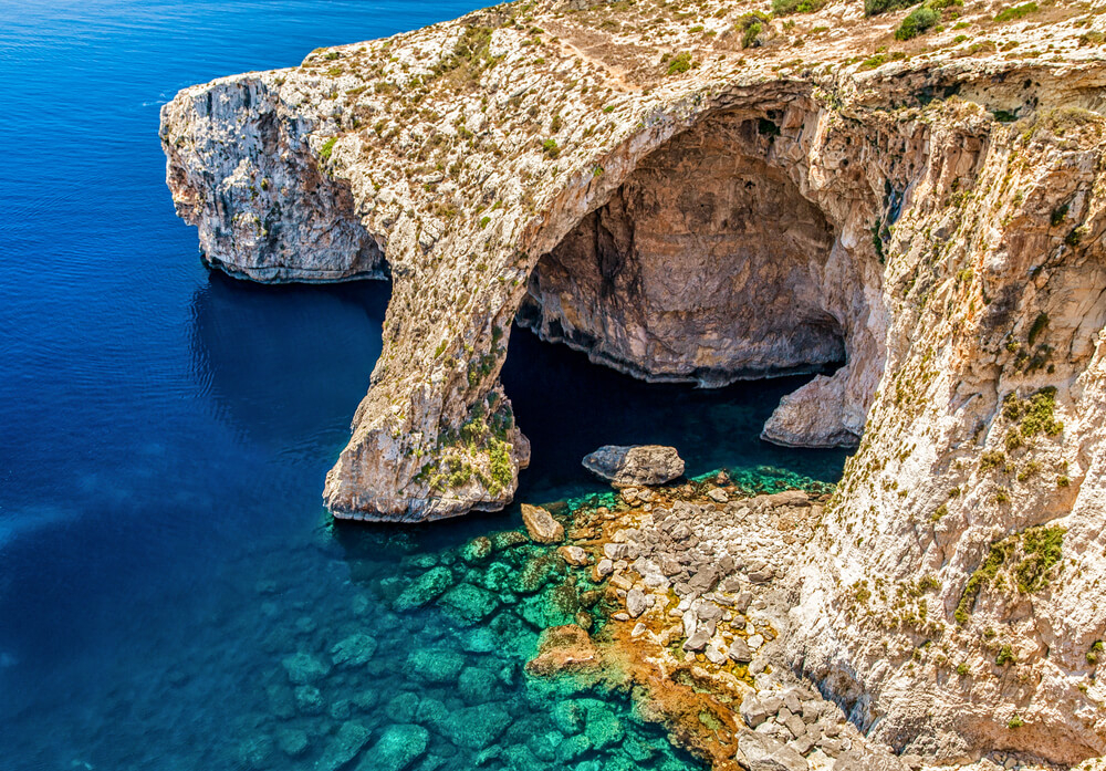 The turquoise waters of the Blue Grotto with two boats on the water