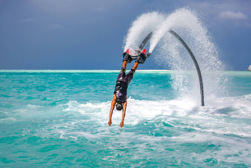 A man flies on a flyboard, one of many thrilling water sports in Aruba.