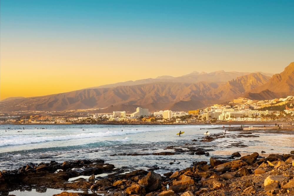 Tenerife Jet Ski: The sun setting over the Las Americas beach with buildings in the background