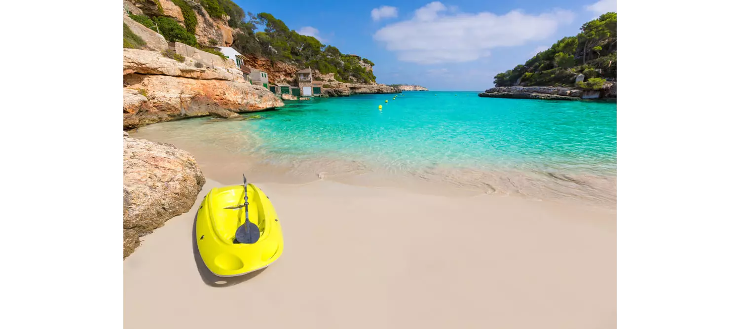 Watersports in Mallorca: Yellow kayak on golden sand with turquoise water in the background