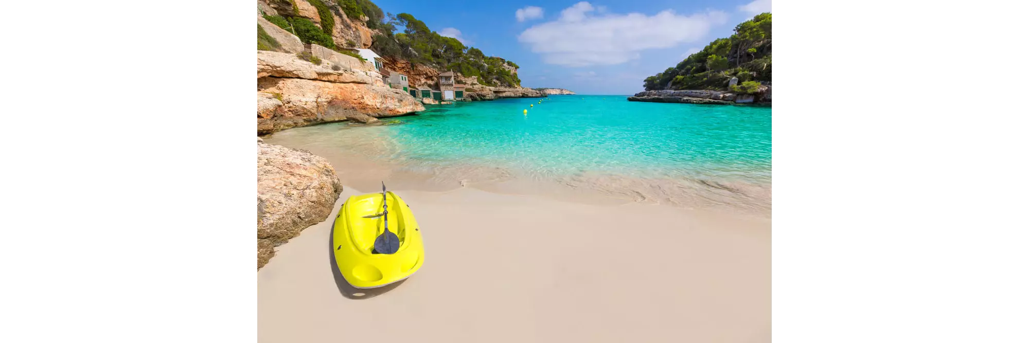 Watersports in Mallorca: Yellow kayak on golden sand with turquoise water in the background