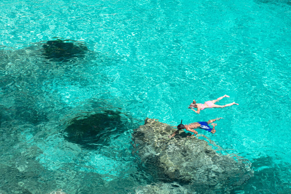 Snorkelling in Mallorca: Man and woman snorkelling in crystal clear topaz waters