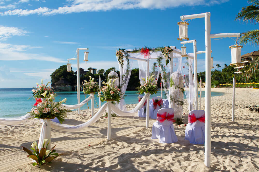 Wedding destinations: A white Maldives beach with a white altar-style arch and chairs