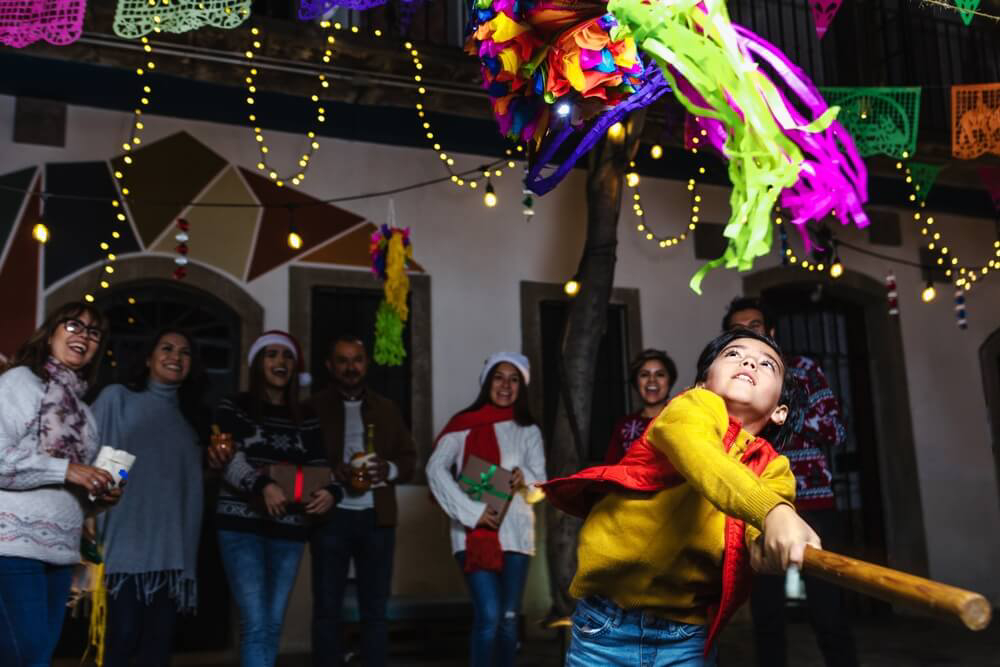 Mittelamerikanische Weihnachtstraditionen: Kind zerschlägt eine Piñata.