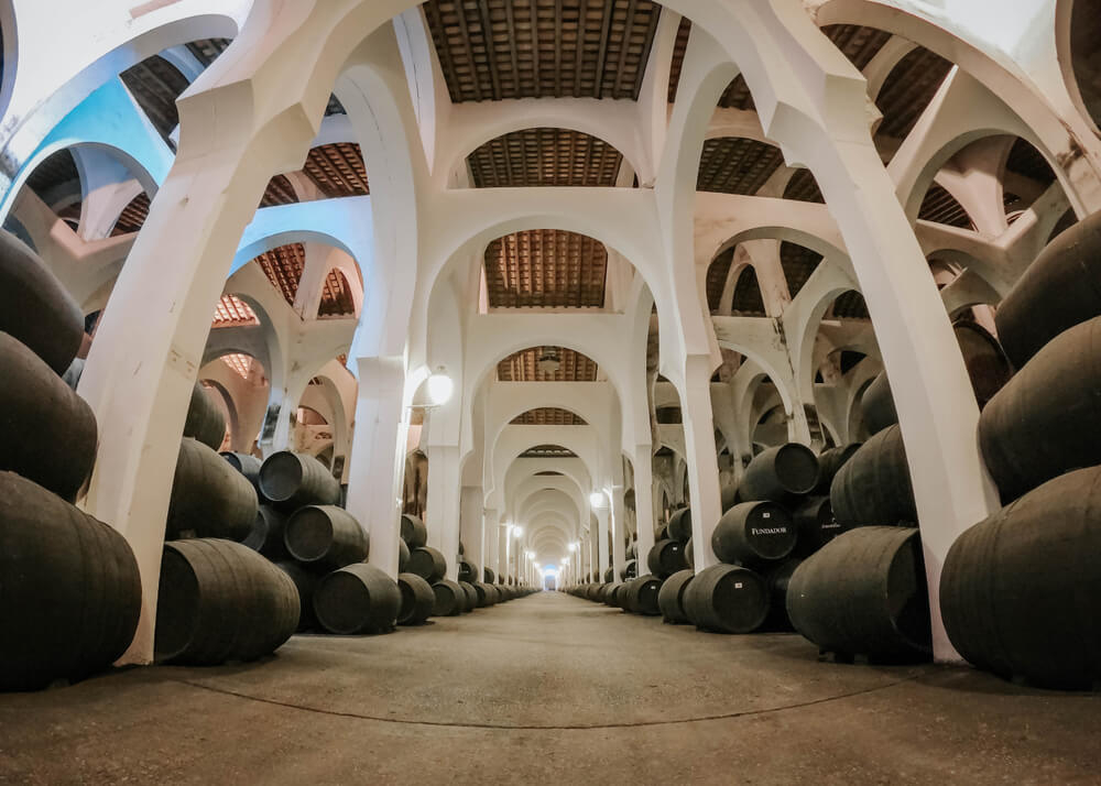 Wine from southern Spain: Inside the cask hall with white pillars and black casks