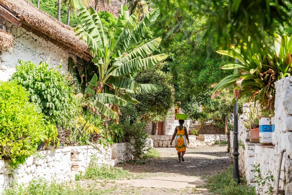 Cidade Velha: A timeworn cobbled street, traditional houses and a woman walking