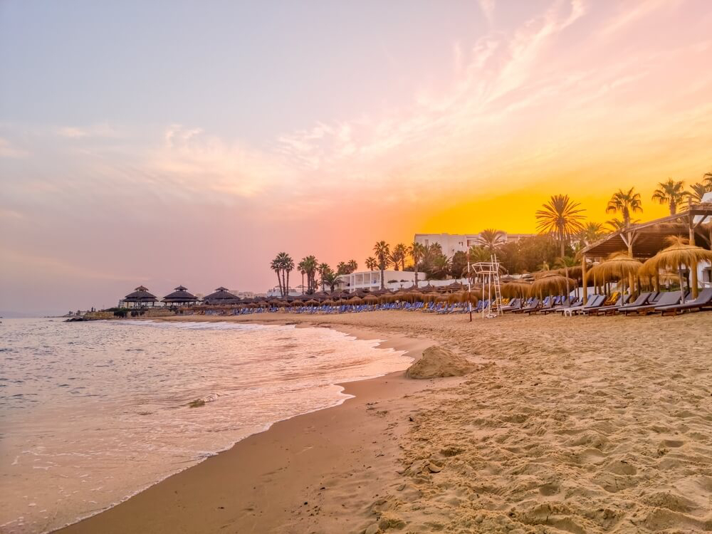 Hammamet: A white sand beach at sunset with parasols and loungers